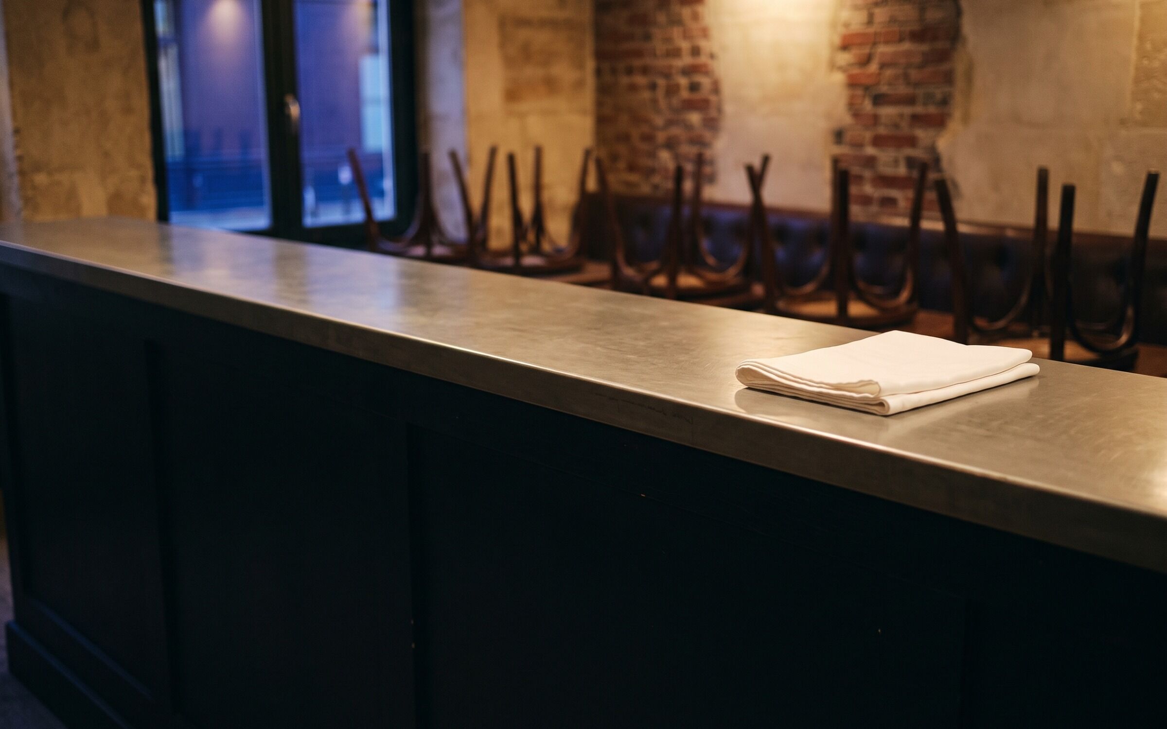 The counter wiped down at closing with the chairs upended behind it