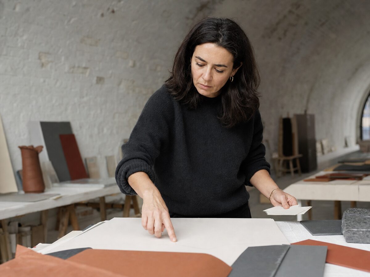 Ines Ferreira sorting interview cards across a blank strategy sheet in the Foundry studio